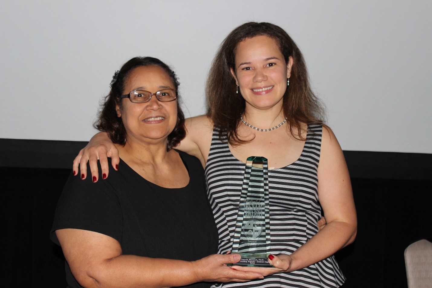 Francis photographed with her mom holding an award.